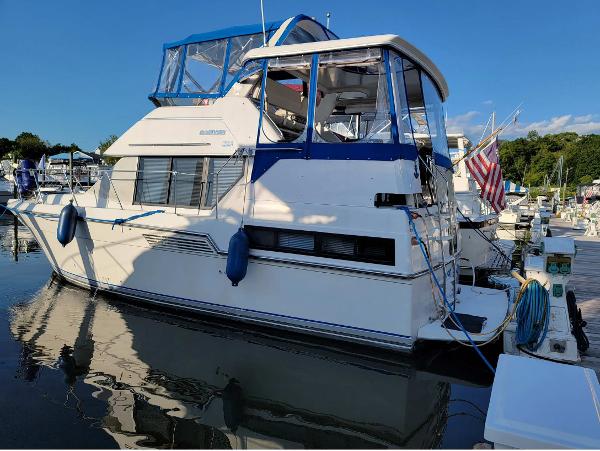 Carver 33 Aft Cabin 1992 Carver 33 Aft Cabin yacht docked in a marina, featuring blue accents and an American flag.