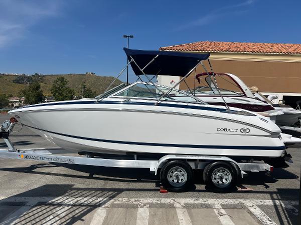 Cobalt 212 2008 Cobalt 212 boat on trailer with blue canopy in parking lot.