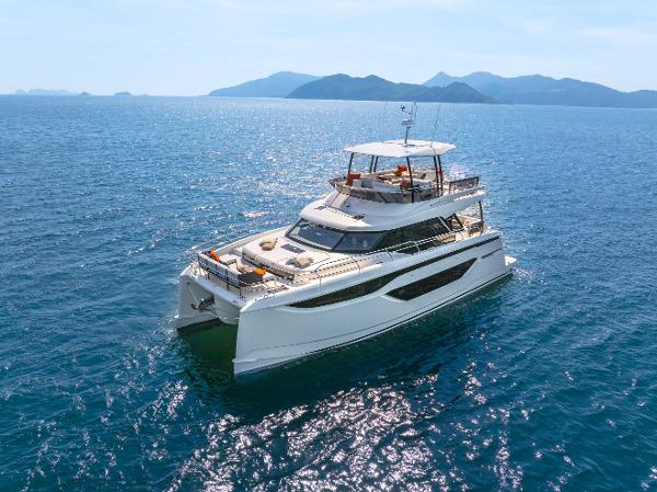 Prestige M48 Luxury Prestige M48 yacht cruising on open sea, 2025 model, with scenic mountain backdrop.