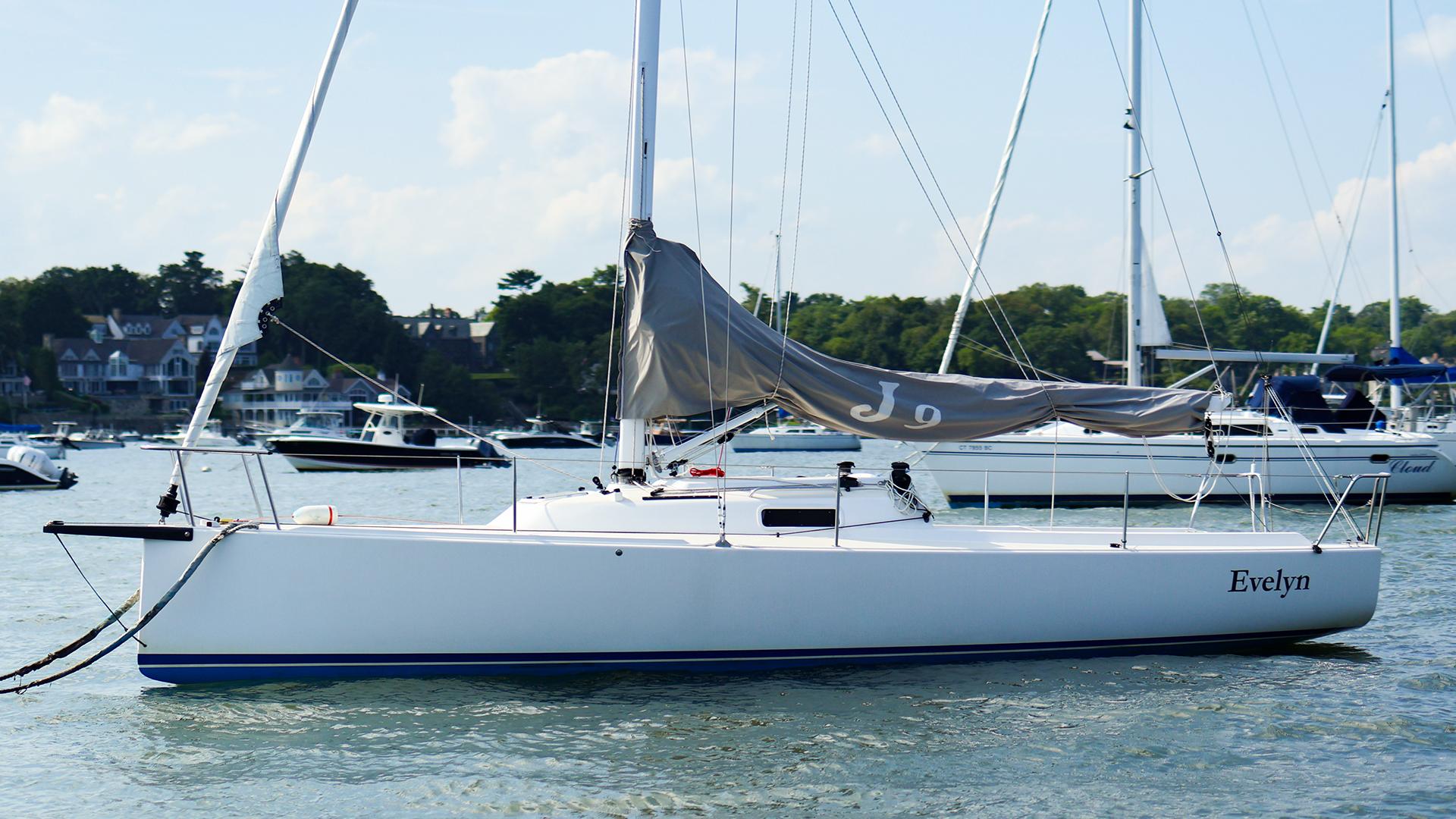 J Boats J/9 2022 J Boats J/9 sailboat named Evelyn on calm water, surrounded by other boats.