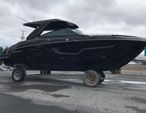 Cruisers Yachts 34GLS OB SOUTH BEACH 2023 Cruisers Yachts 34GLS OB SOUTH BEACH on trailer, sleek black design, overcast sky.