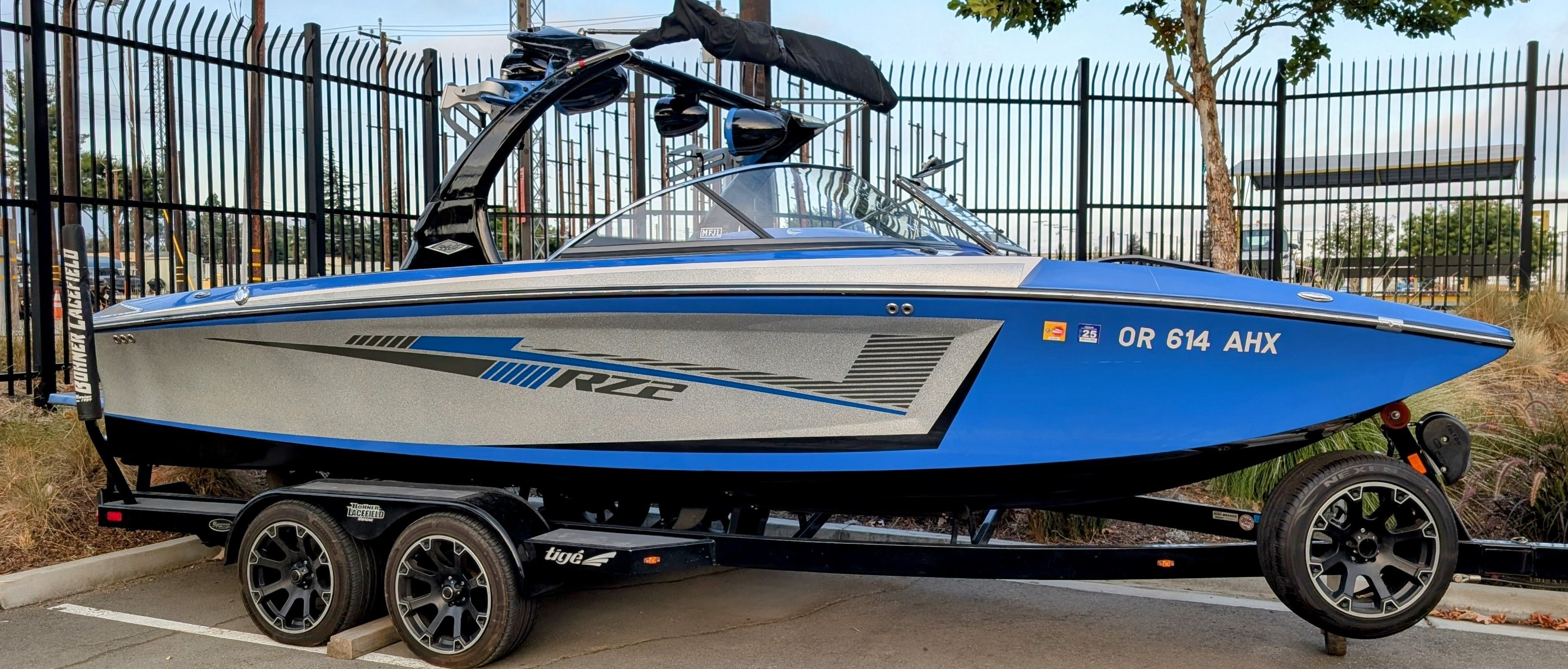 Tigé RZ2 2016 Tigé RZ2 boat in blue and silver, parked on a trailer.