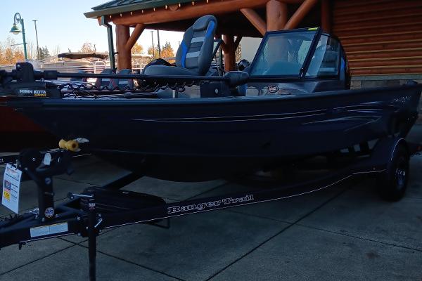 Ranger VS1682SC Angler 2023 Ranger VS1682SC Angler boat on a trailer outside a wooden building.