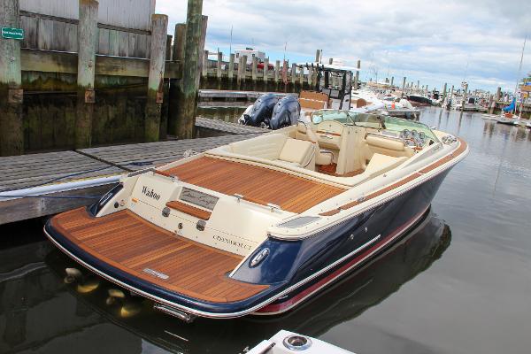 Chris-Craft Launch 28 2013 Chris-Craft Launch 28 boat docked at a marina, featuring a wooden deck and luxurious seating.