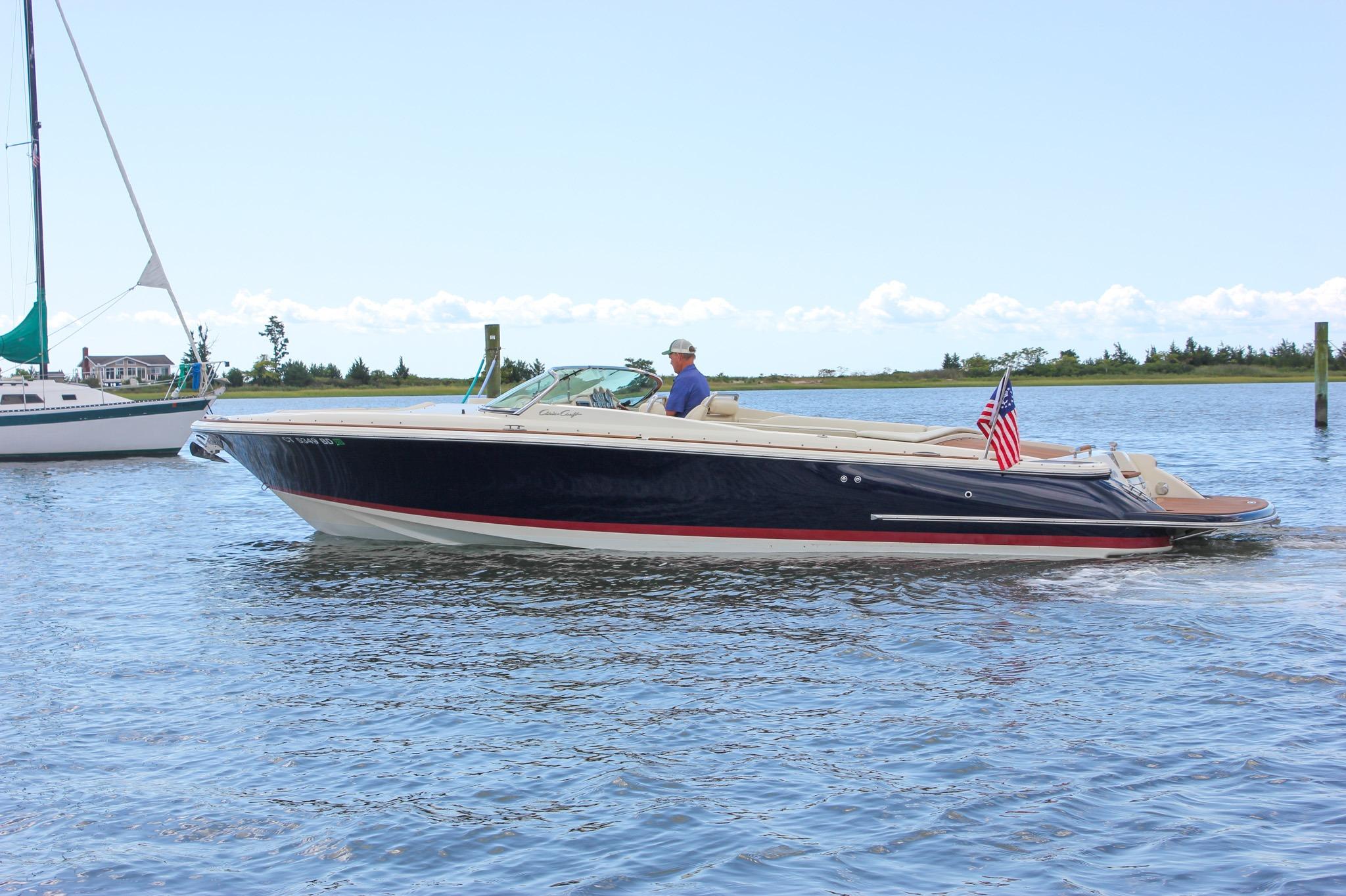 Chris-Craft Launch 28 2013 Chris-Craft Launch 28 boat cruising on a calm lake with American flag.