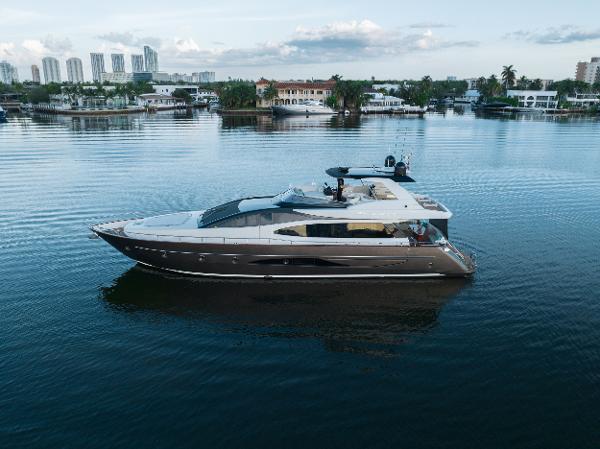 Riva 75 Venere 2012 Riva 75 Venere luxury yacht cruising in a serene marina with cityscape background.