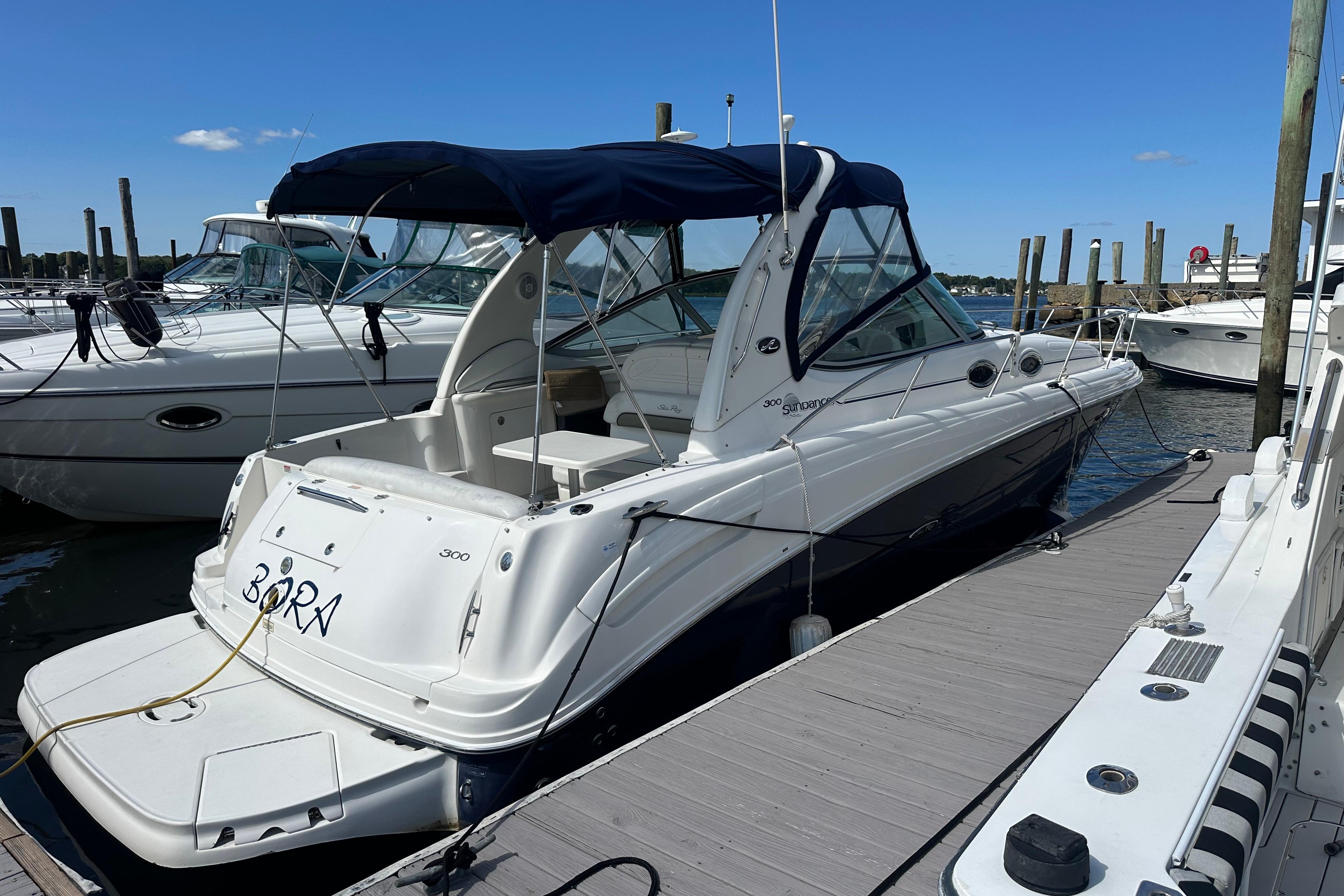 Sea Ray 300 Sundancer 2006 Sea Ray 300 Sundancer docked at marina under clear blue sky.