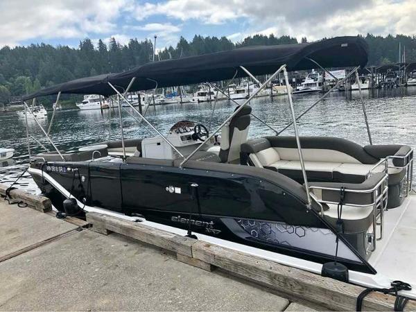Bayliner Element XR7 2019 Bayliner Element XR7 boat docked at marina with canopy and seating.