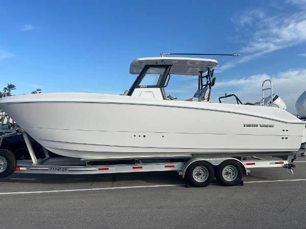 Twin Vee 280 GFX2 CC 2025 Twin Vee 280 GFX2 CC boat on trailer, side view, clear sky background.