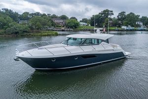 Tiara Yachts C44 Coupe 2020 Tiara Yachts C44 Coupe cruising on a serene lake with lush greenery.