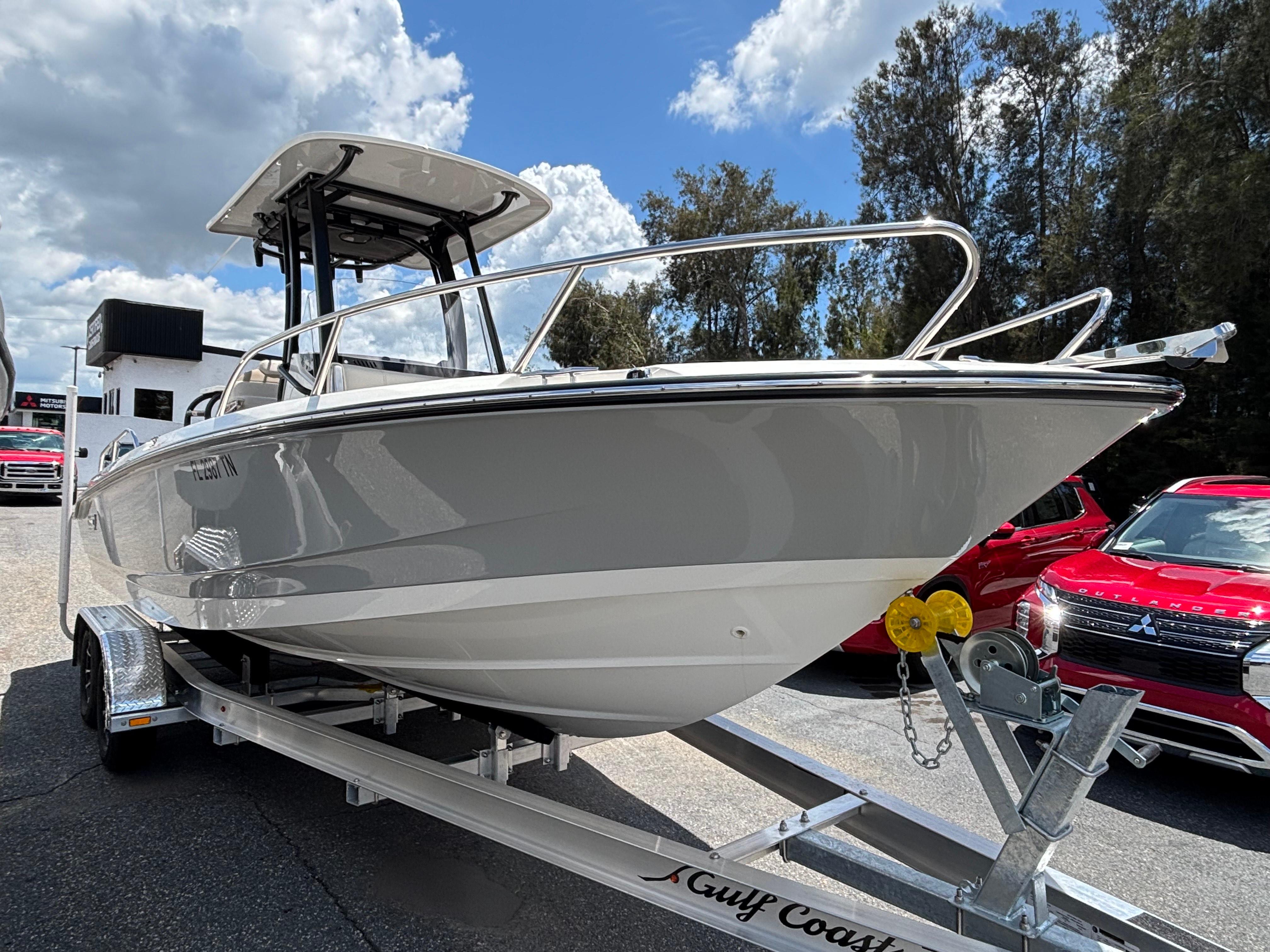 Boston Whaler 220 Dauntless 2023 Boston Whaler 220 Dauntless boat on trailer, parked outdoors under a cloudy sky.