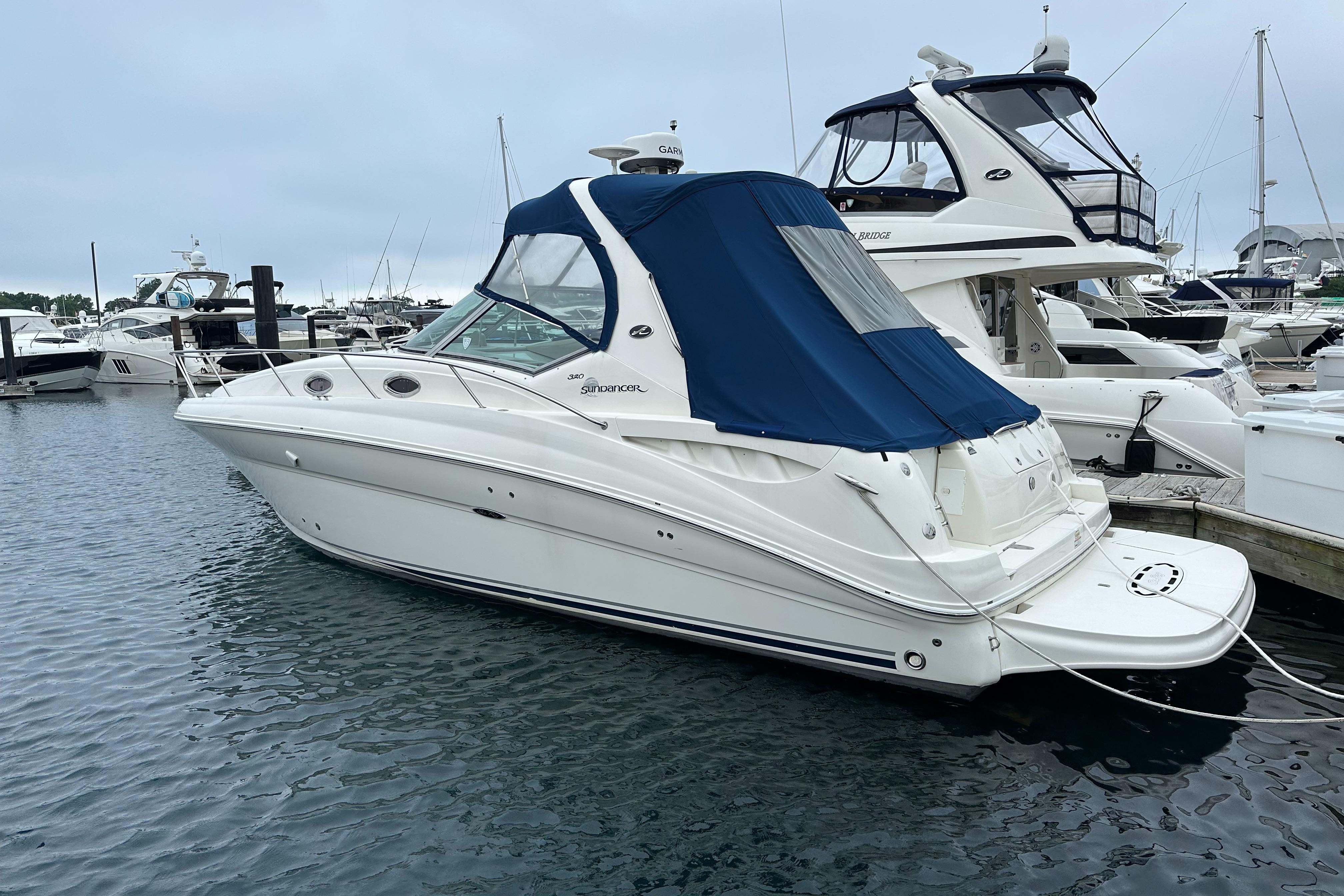 Sea Ray 320 Sundancer 2006 Sea Ray 320 Sundancer yacht docked in marina, featuring blue canopy.