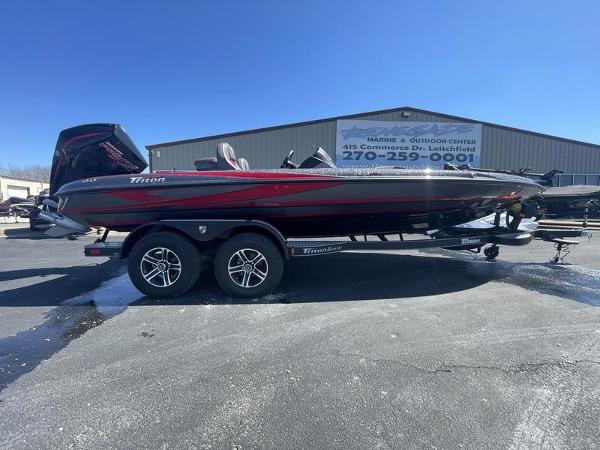 Triton 21 TrX Patriot 2024 Triton 21 TrX Patriot boat on a trailer outside a marine center.
