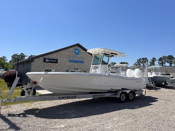 Caymas 281 HB 2025 Caymas 281 HB boat on trailer outside dealership under clear blue sky.