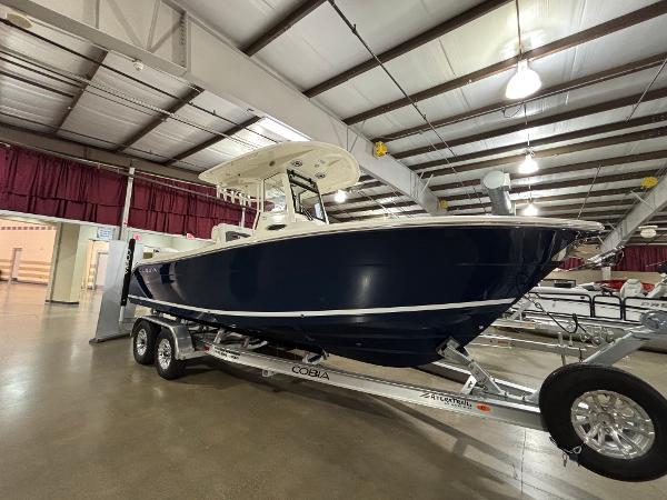 Cobia 240 Center Console 2025 Cobia 240 Center Console boat on trailer in showroom.