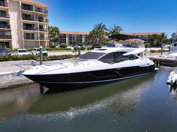 Sunseeker 74 Sport Yacht 2020 Sunseeker 74 Sport Yacht docked near waterfront apartments.