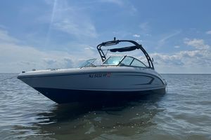 Chaparral 23 SSi OB 2021 Chaparral 23 SSi boat on calm water under a clear blue sky.