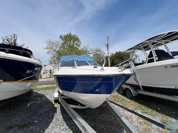 Bayliner 212 2006 Bayliner 212 boat on trailer, parked outdoors under clear sky.