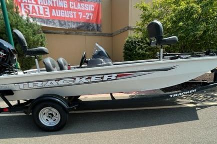 Tracker Pro 170 2026 Tracker Pro 170 boat on trailer, displayed outdoors near sale banner.
