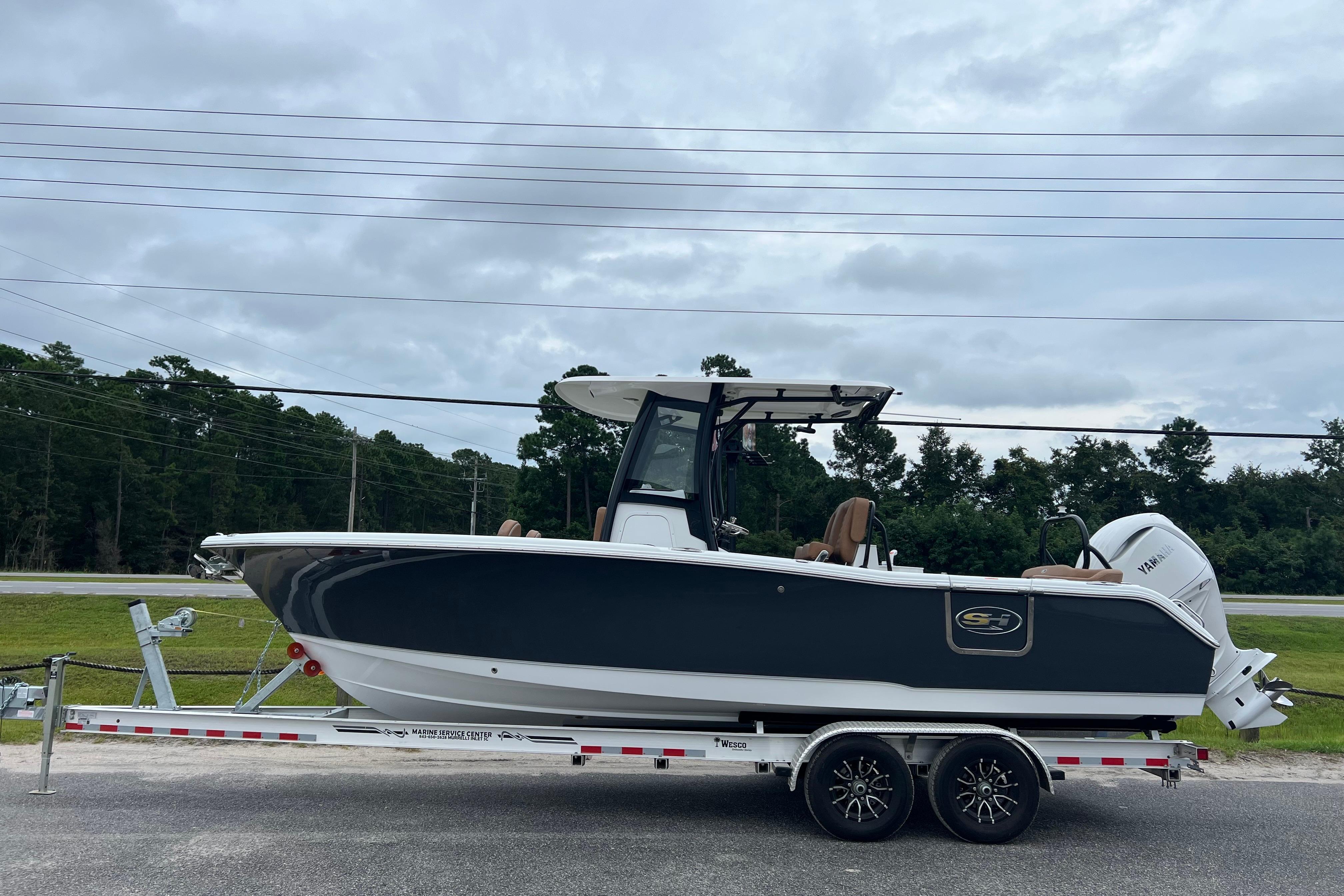 Sea Hunt Ultra 255 SE 2026 Sea Hunt Ultra 255 SE boat on trailer, parked outdoors under cloudy sky.