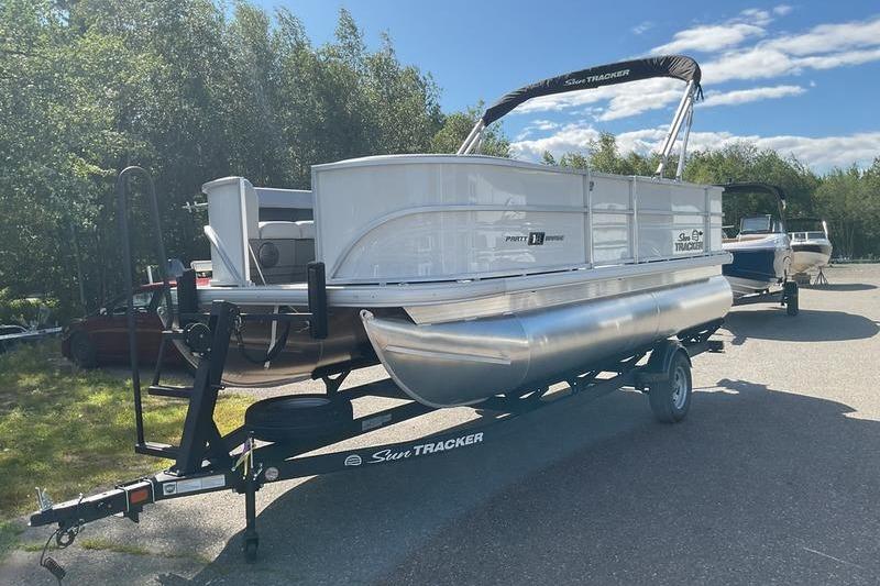 Sun Tracker PB 18 DLX 2026 Sun Tracker PB 18 DLX pontoon boat on trailer, parked outdoors.