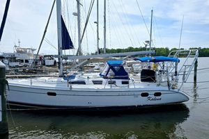 Hunter 386 2003 Hunter 386 sailboat docked at marina with blue canopy and clear sky.