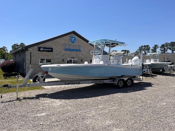 Caymas 26 HB 2025 Caymas 26 HB boat on trailer outside dealership under clear blue sky.