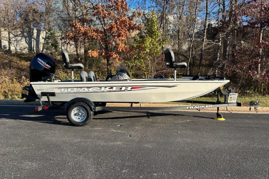 Tracker Pro 170 2026 Tracker Pro 170 boat on trailer, parked outdoors with autumn trees in background.