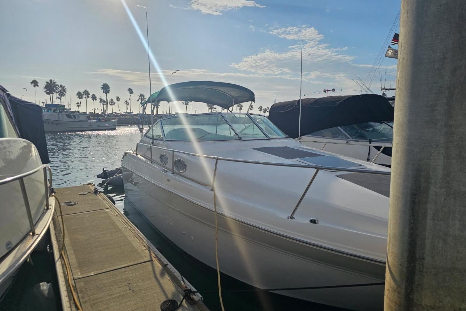 Sea Ray 270 Sundancer 1999 Sea Ray 270 Sundancer docked at marina under sunny sky.