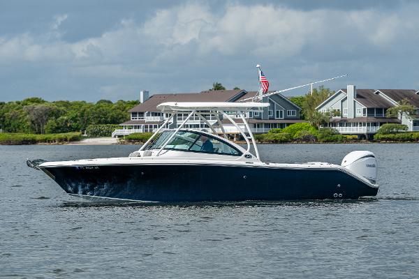 Pursuit DC 246 Dual Console 2021 Pursuit DC 246 Dual Console boat on water, with houses in the background.