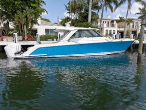 Tiara Yachts 48 LS 2023 Tiara Yachts 48 LS in vibrant blue, docked by waterfront homes.