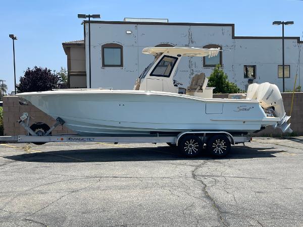 Scout 260 LXF 2024 Scout 260 LXF boat on trailer in parking lot.