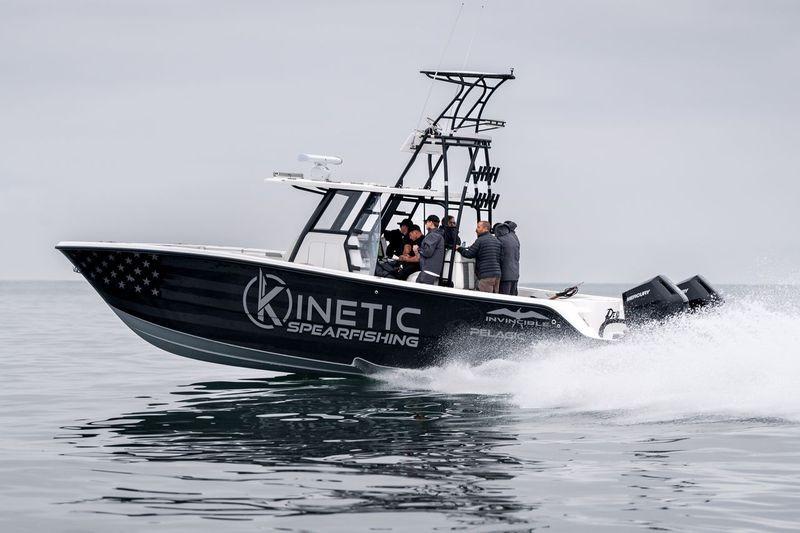 Invincible 33 Catamaran 2024 Invincible 33 Catamaran speeding on water, featuring "Kinetic Spearfishing" branding.
