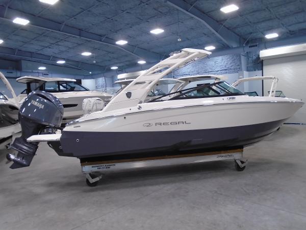 Regal LX2 2025 Regal LX2 boat in showroom, featuring sleek design and Yamaha outboard motor.