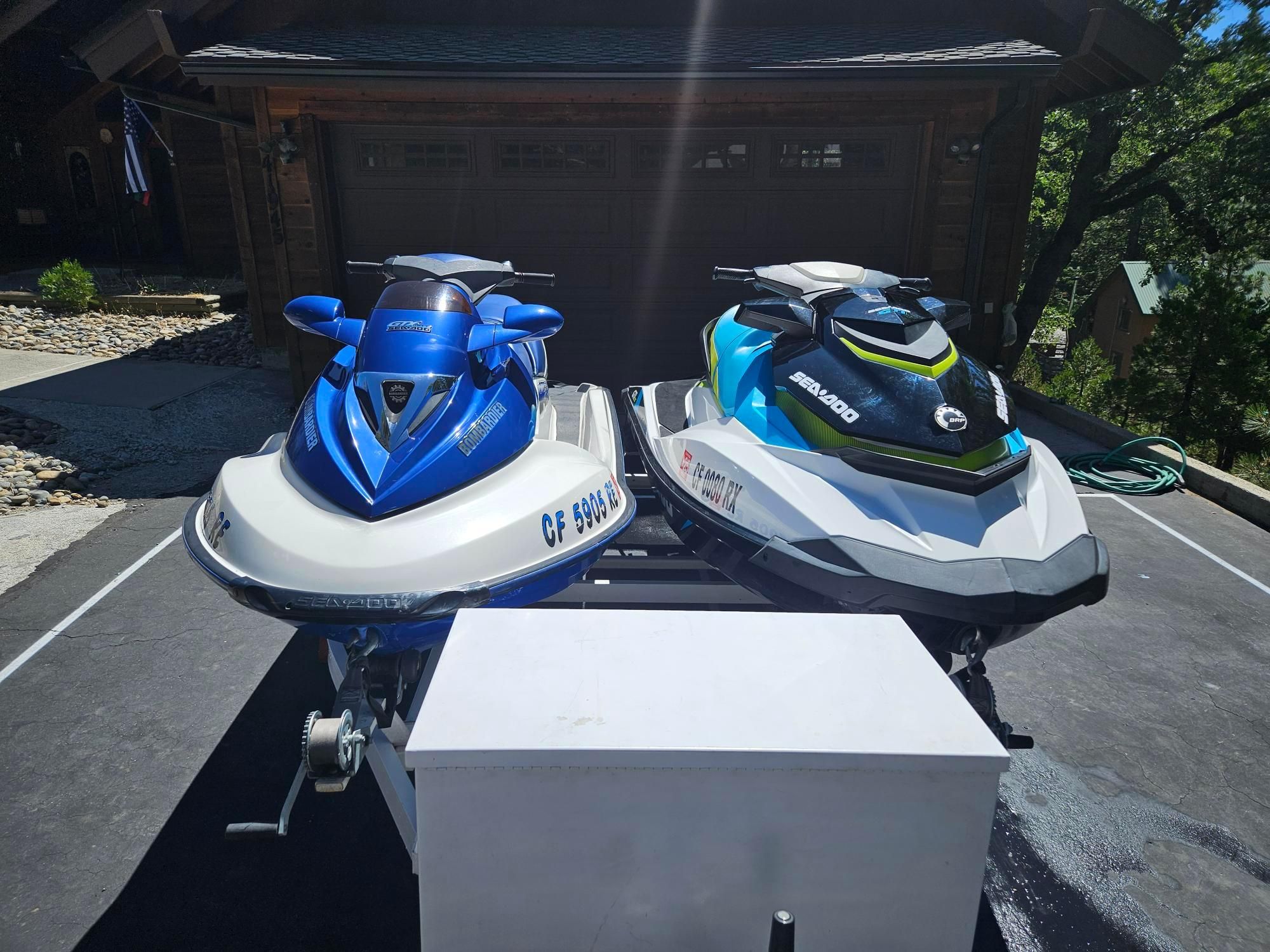 Sea-Doo GTI 130/GTX 4TEC Two 2015 Sea-Doo GTI 130/GTX 4TEC jet skis parked on a driveway.