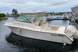 Grady-White Express 370 2022 Grady-White Express 370 boat docked in a marina, featuring sleek design and Yamaha engines.