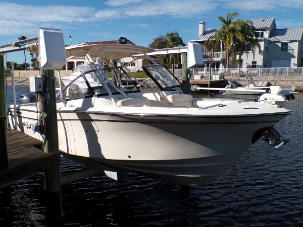 Grady-White Freedom 275 2016 Grady-White Freedom 275 boat docked by waterfront homes under a clear sky.