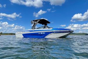 Tigé 23ZX 2022 Tigé 23ZX boat on water under blue sky with clouds.