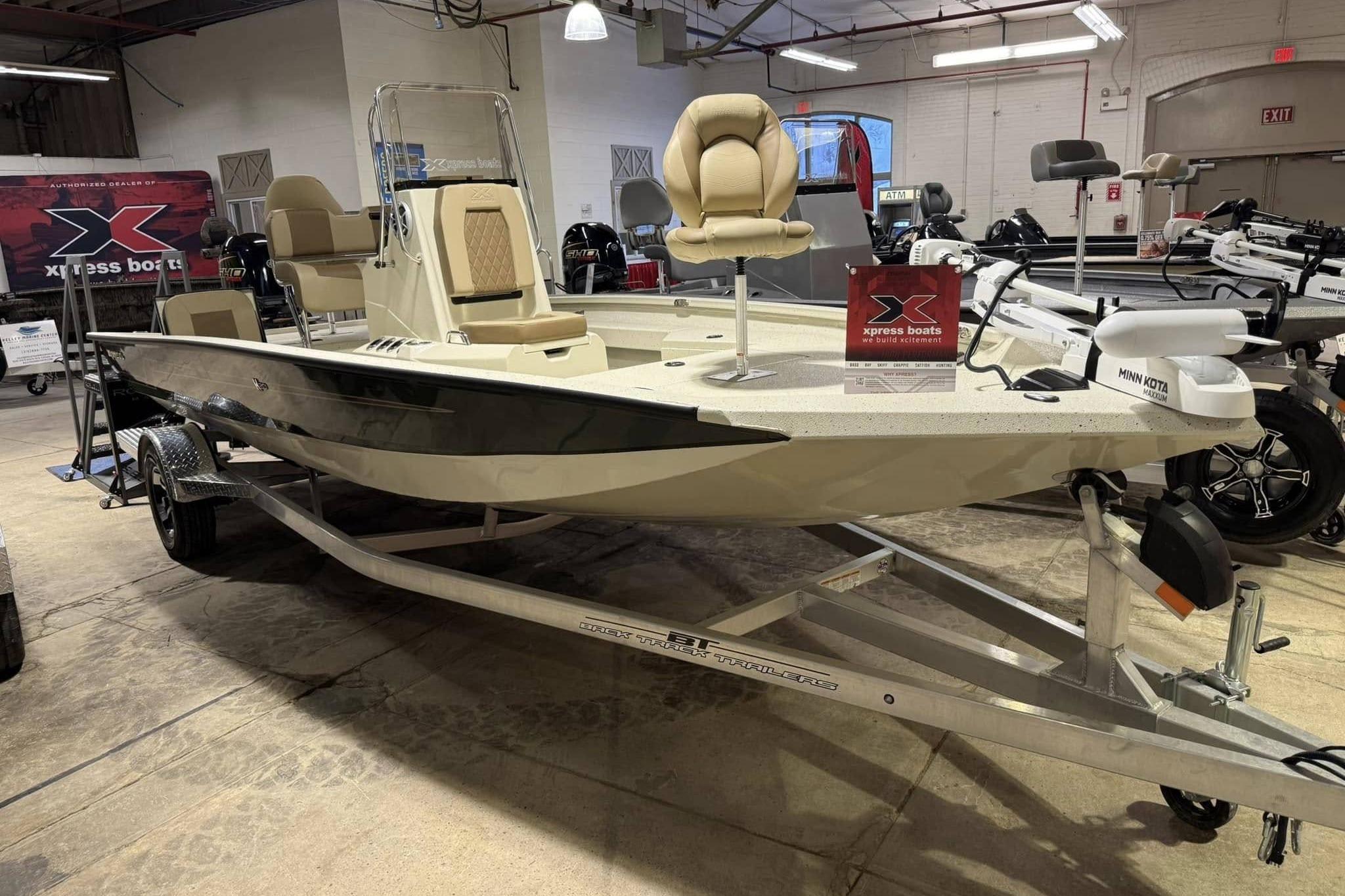 Xpress H20B Bay 2025 Xpress H20B Bay boat on display in showroom with trailer.