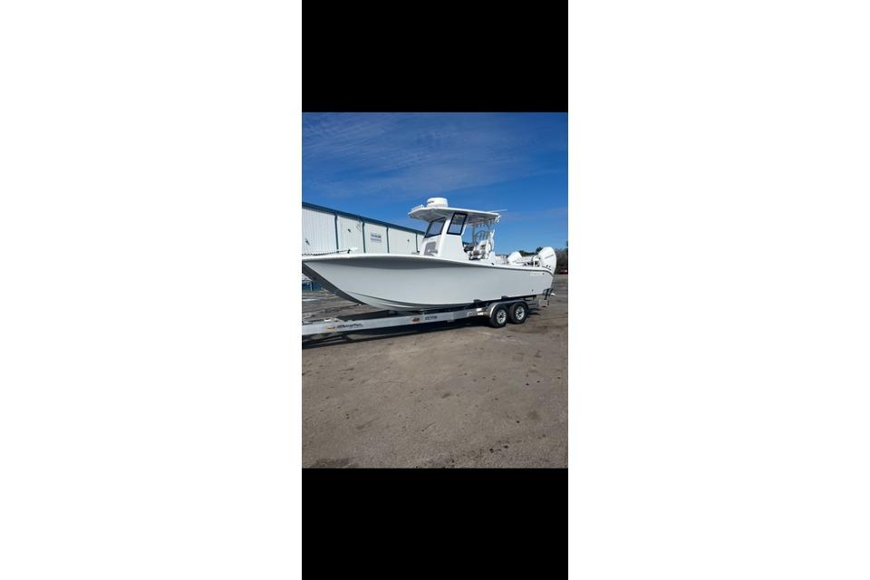 Costa Custom Boats 264 2024 Costa Custom Boats 260 on trailer, parked outdoors under clear blue sky.