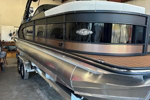 Manitou 25LX SRW 2024 Manitou 25LX SRW pontoon boat in a garage.