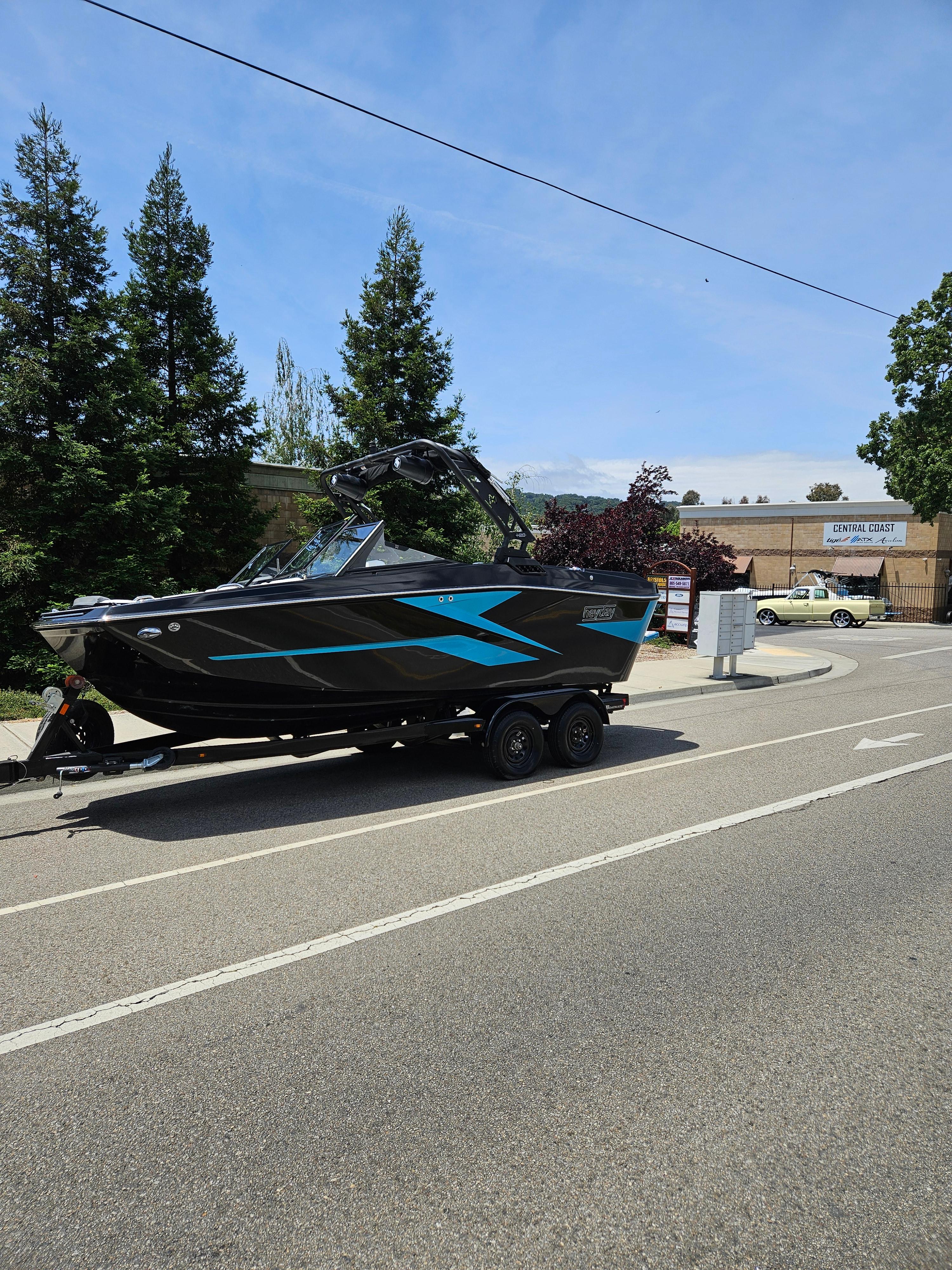 HEYDAY WAKE BOATS H20 2023 HEYDAY WAKE BOATS H20 on trailer, parked on roadside with trees in background.