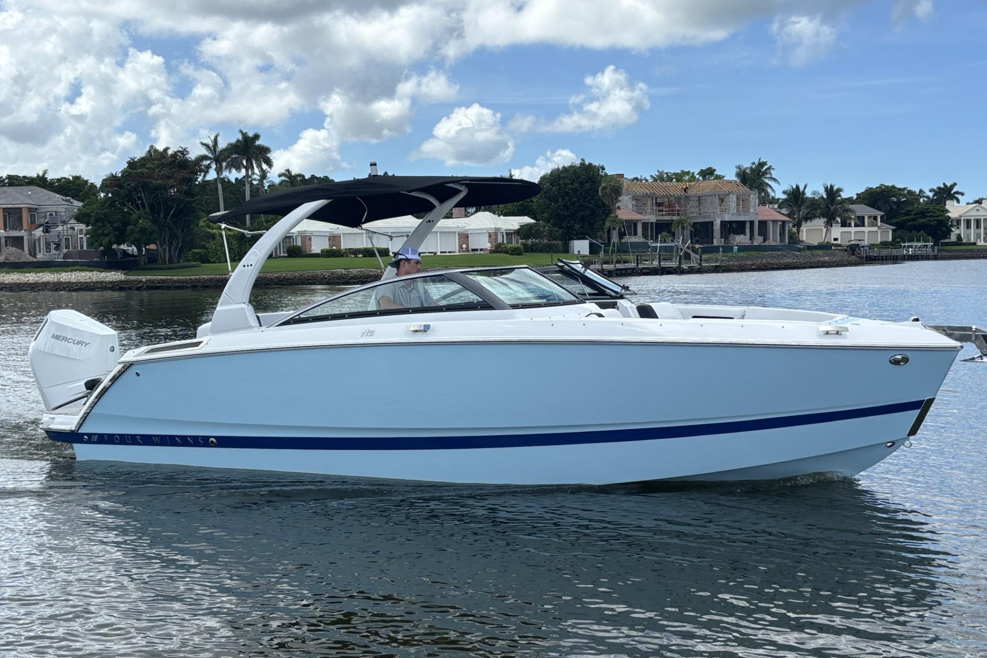 Four Winns H6 2026 Four Winns H6 boat on calm water, featuring sleek design and modern architecture.