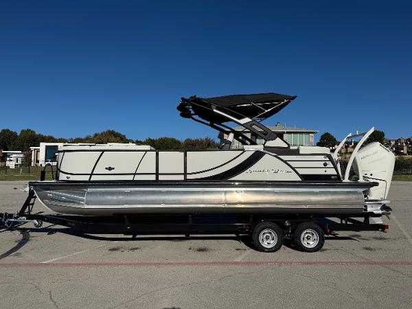 South Bay 525 RS 2025 South Bay 525 RS pontoon boat on trailer, parked outdoors under clear blue sky.