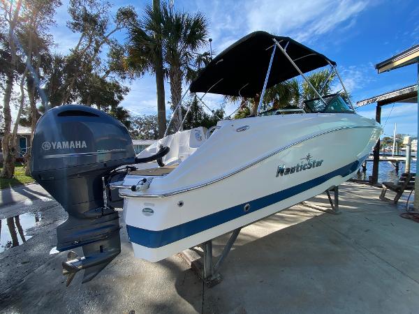 NauticStar 223 DC 2022 NauticStar 223 DC boat with Yamaha engine, docked under a clear blue sky.