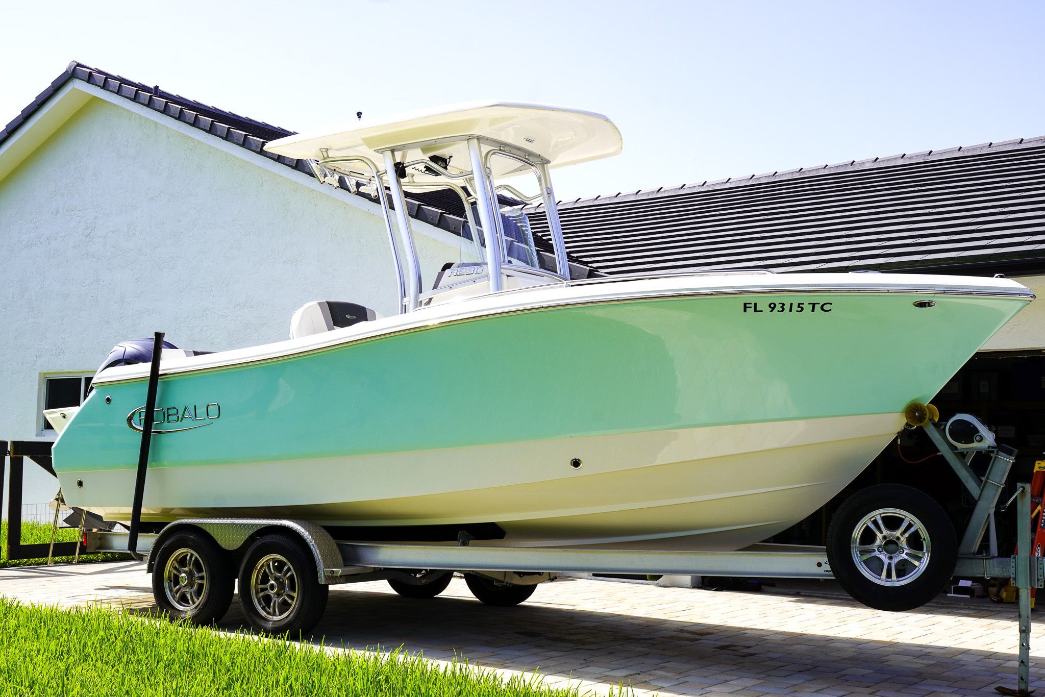 Robalo R230 Center Console 2022 Robalo R230 Center Console boat on trailer, parked near a house.