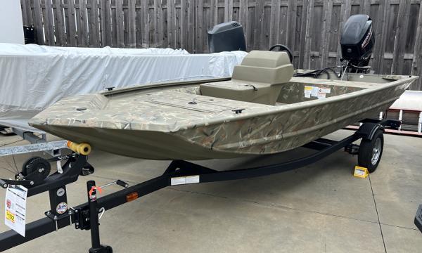 Tracker Grizzly 1648 SC 2024 Tracker Grizzly 1648 SC boat on trailer, camo design, outboard motor, parked outdoors.