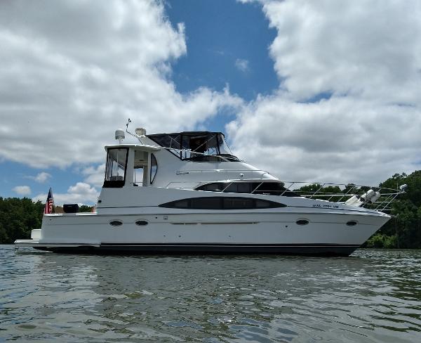Carver 444 Cockpit Motor Yacht 2001 Carver 444 Cockpit Motor Yacht on a calm lake under a partly cloudy sky.