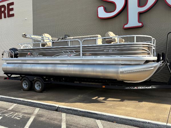 Sun Tracker Sportfish 24 XP3 2023 Sun Tracker Sportfish 24 XP3 pontoon boat on trailer, parked outside a store.