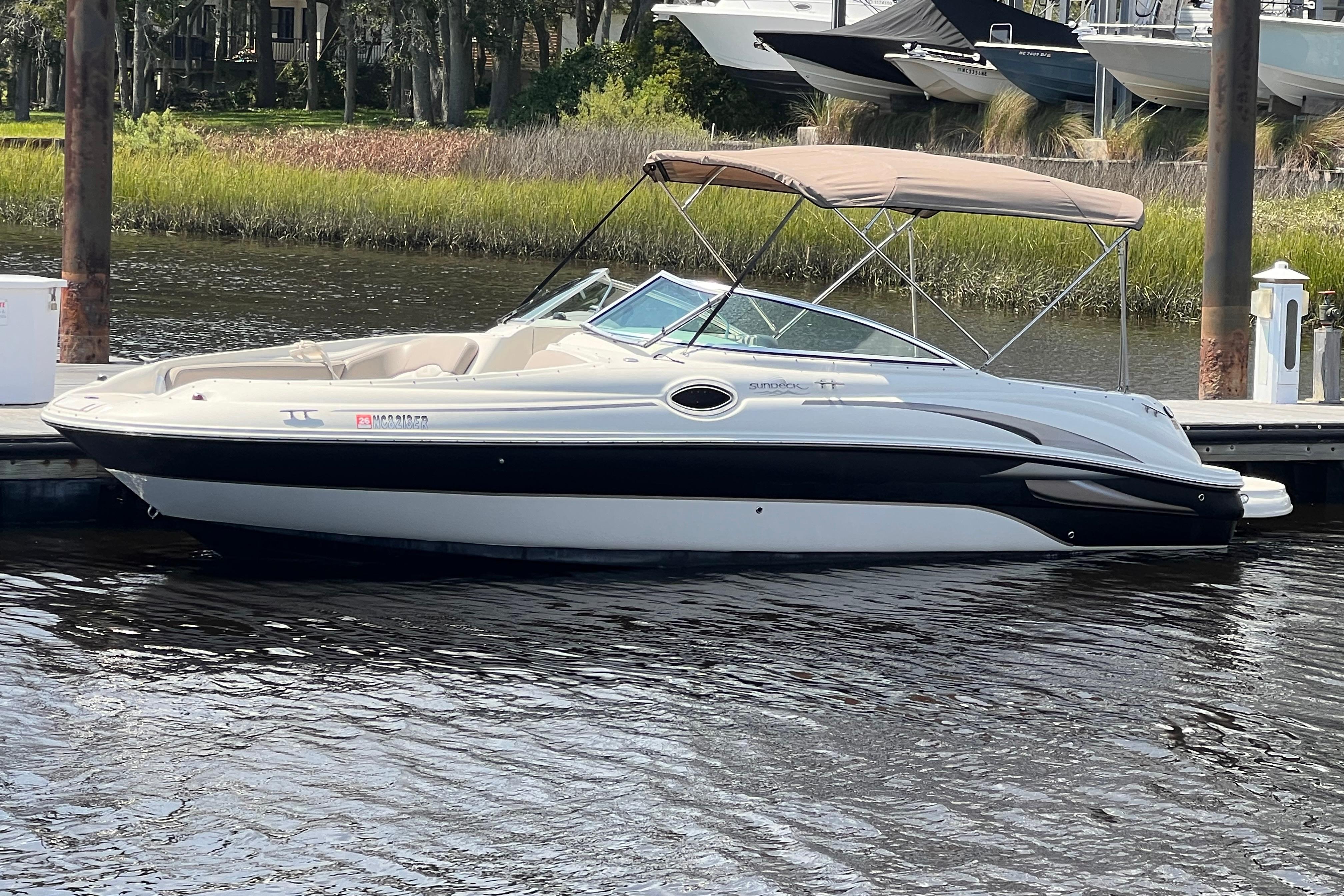 Sea Ray 240 Sundeck 2003 Sea Ray 240 Sundeck boat docked on calm water with a canopy.